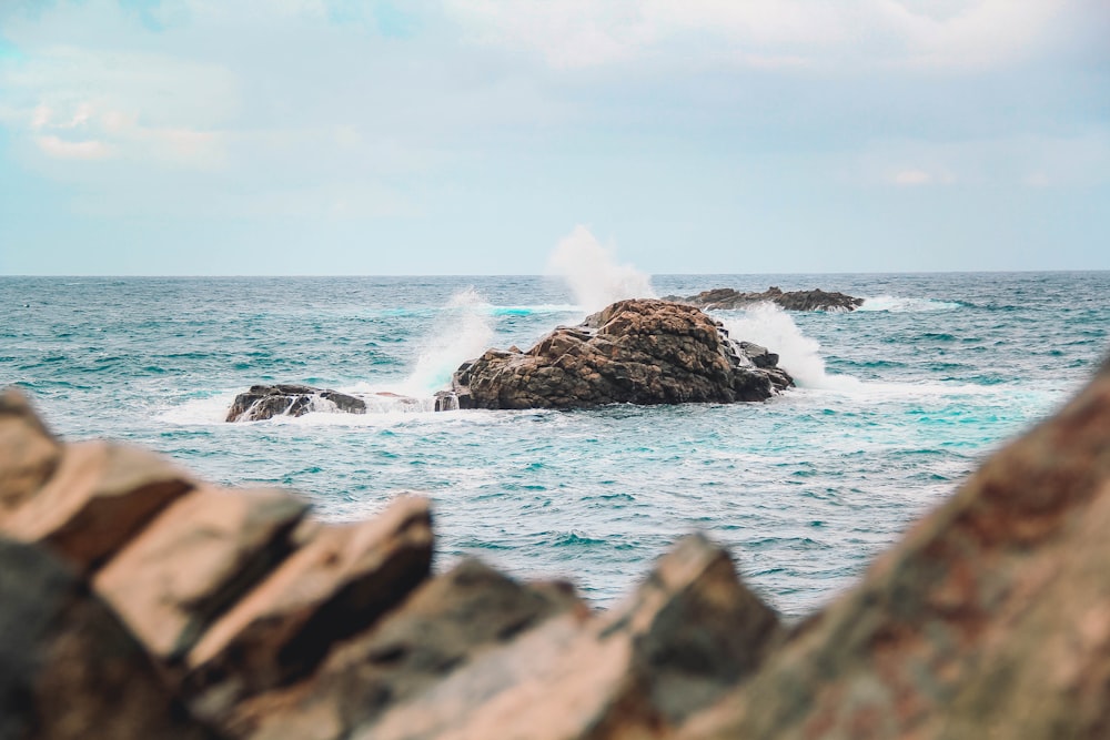 a large body of water with rocks in the foreground