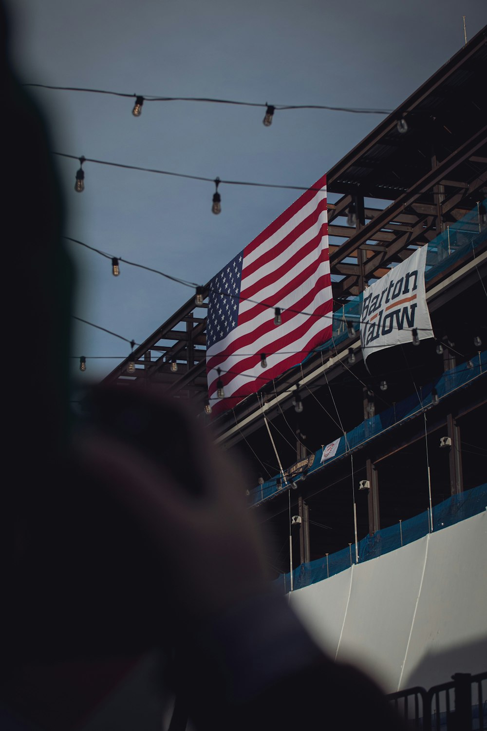 a large american flag hanging from the side of a building