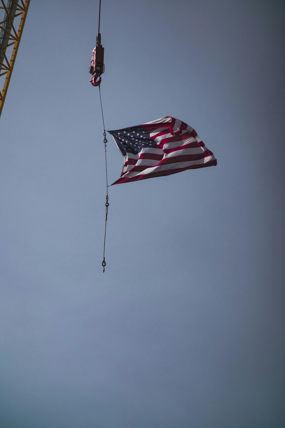 an american flag being lowered from a crane