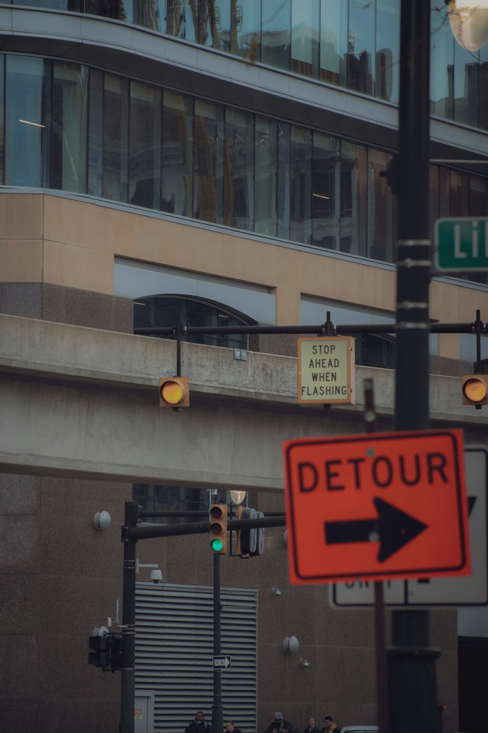 a traffic light with a detour sign above it