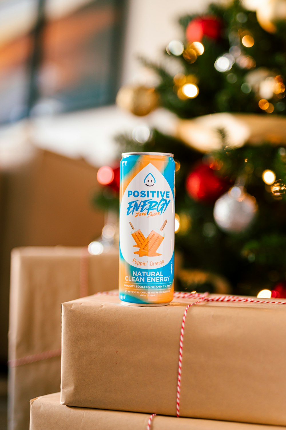 a can of drink sitting on top of a stack of wrapped presents