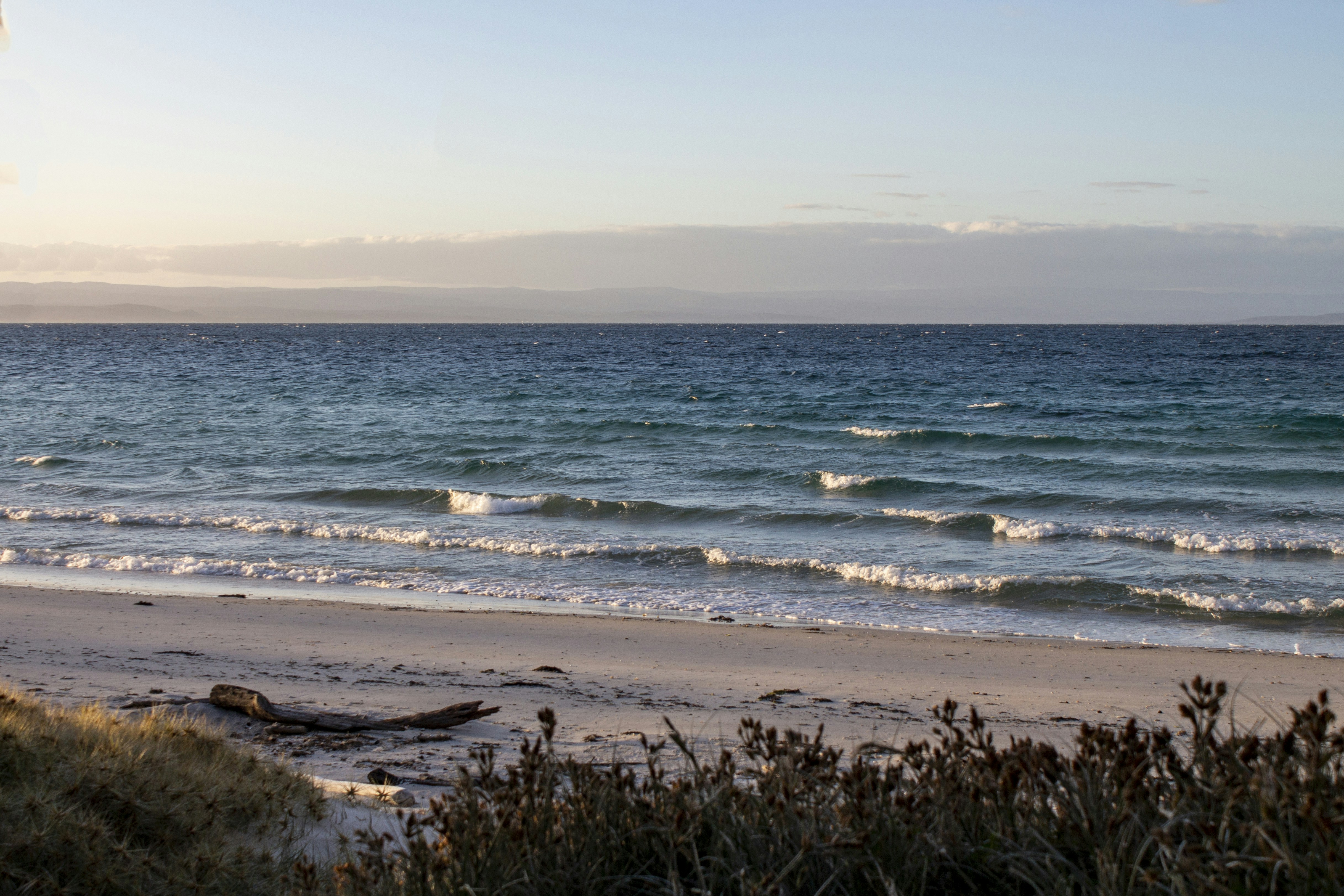 a beach with waves coming in to shore, Hiking the Hazards Circuit in Freycinet Tasmania.