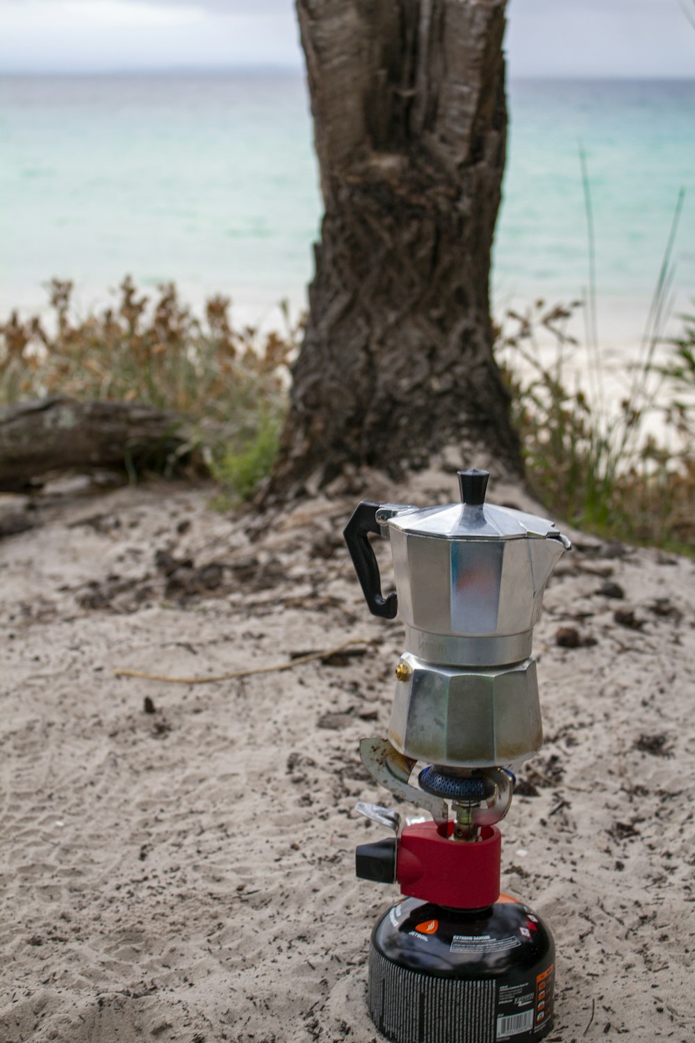 a stove sitting on top of a sandy beach