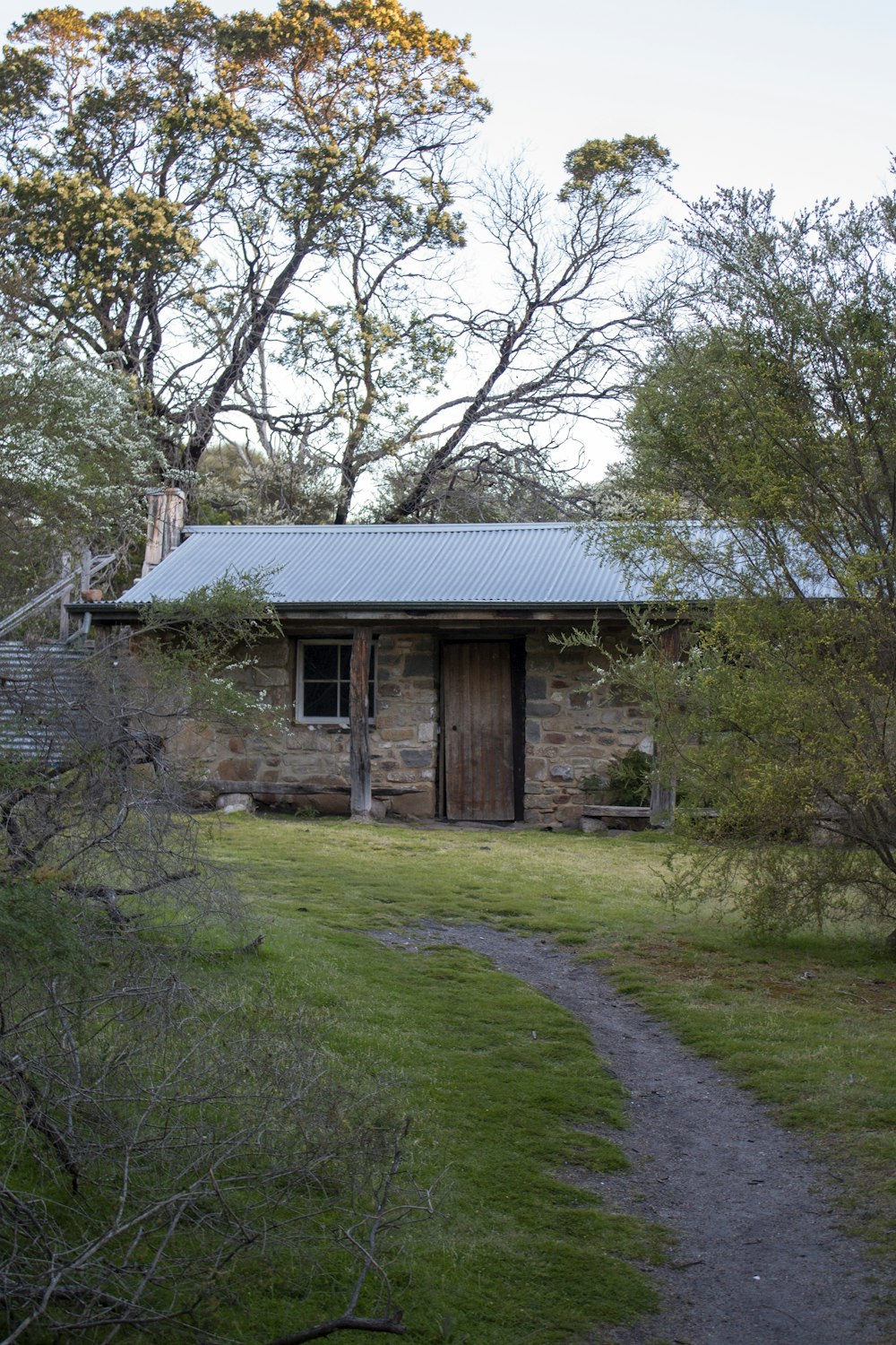 a small stone house with a metal roof