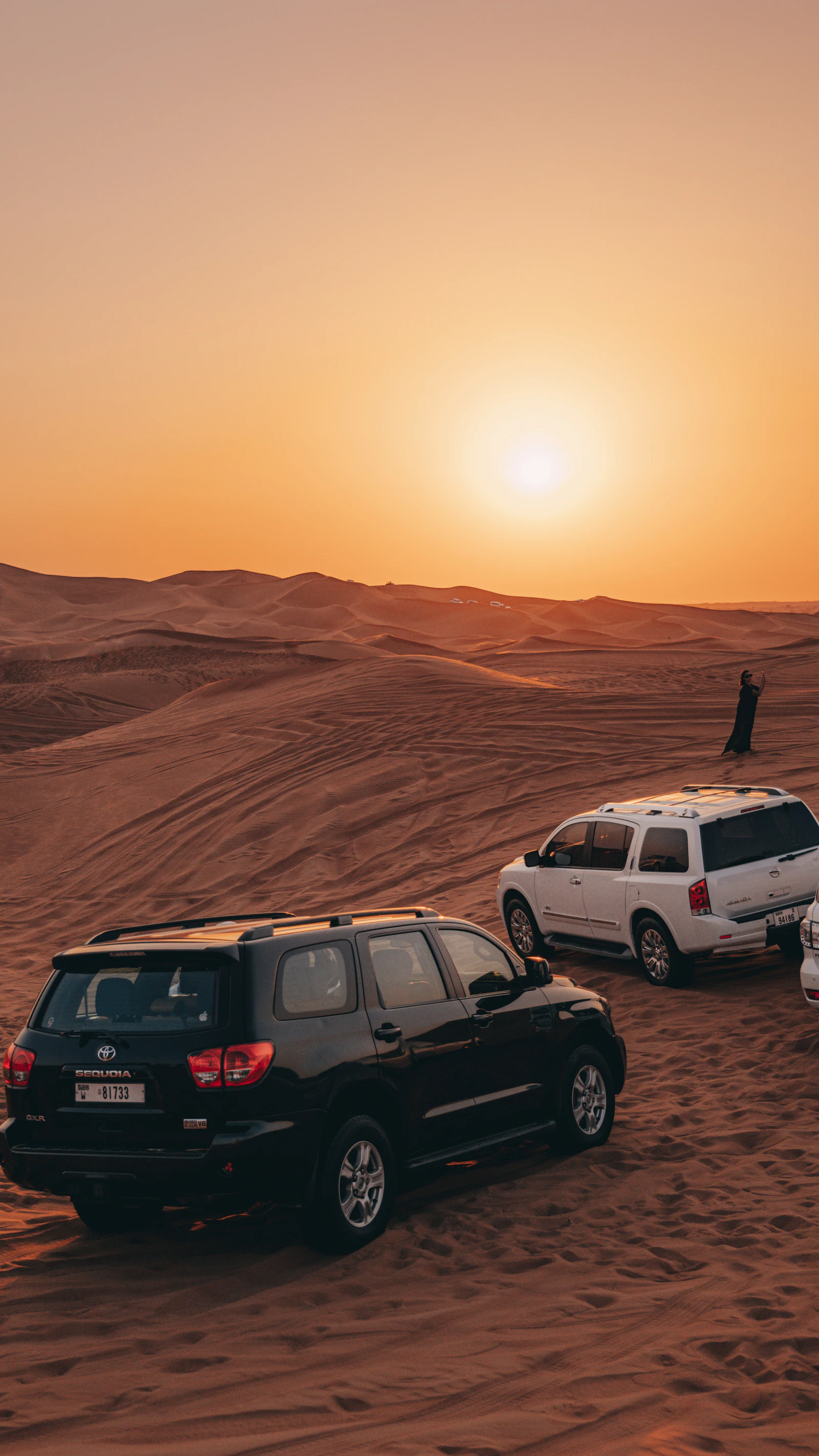 Safari 4x4s parked in the Dubai desert at sunset