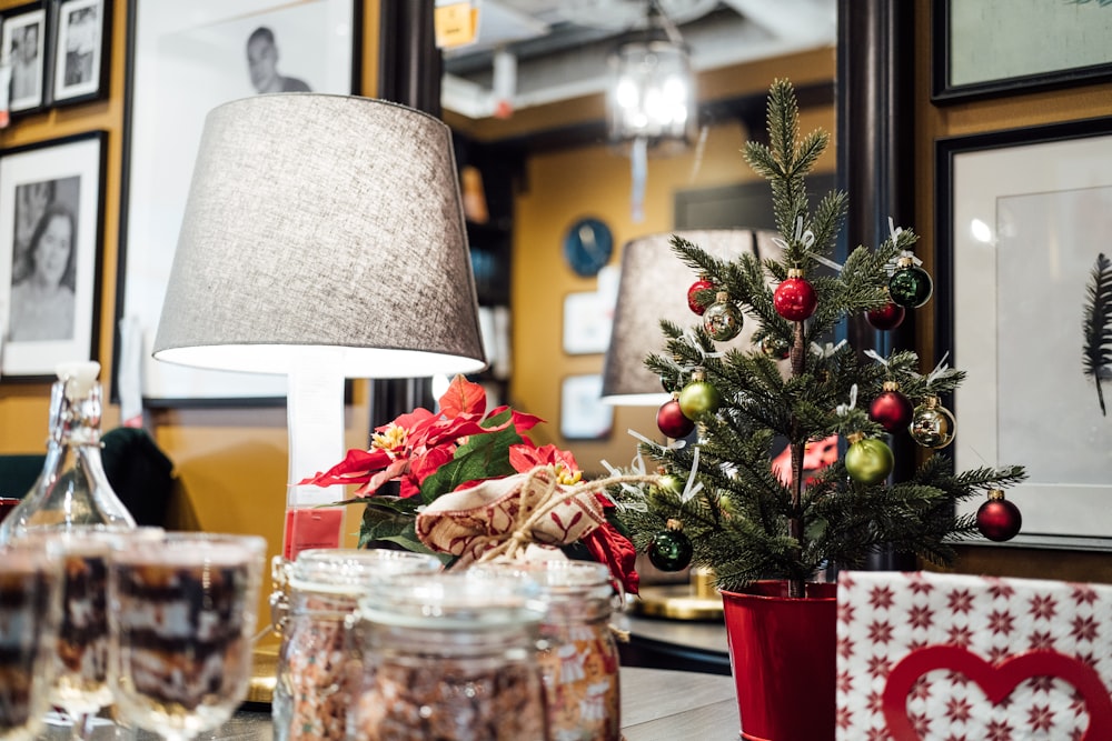 a small christmas tree sitting next to a lamp on a table