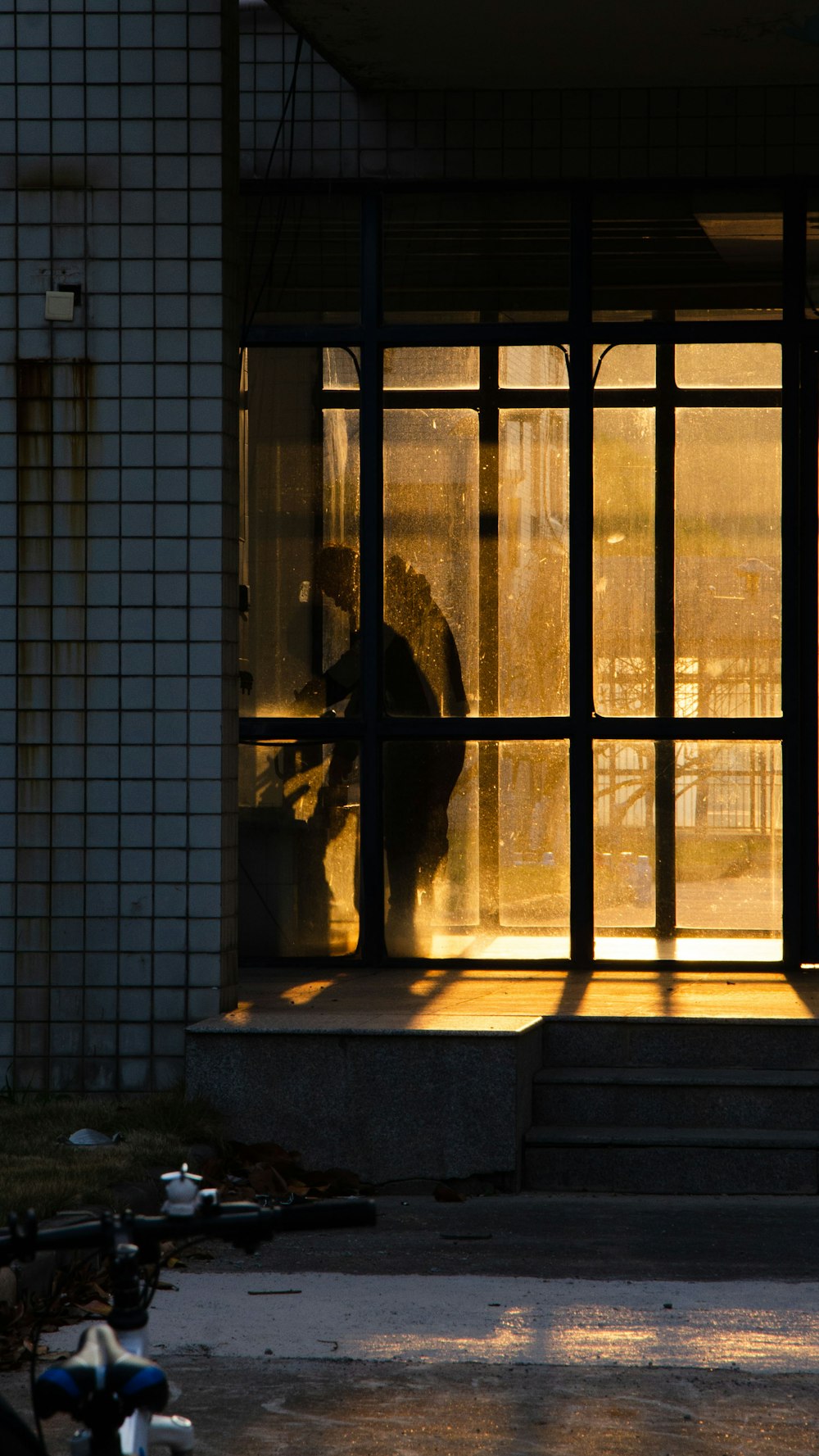 a person standing in front of a window with the sun shining through