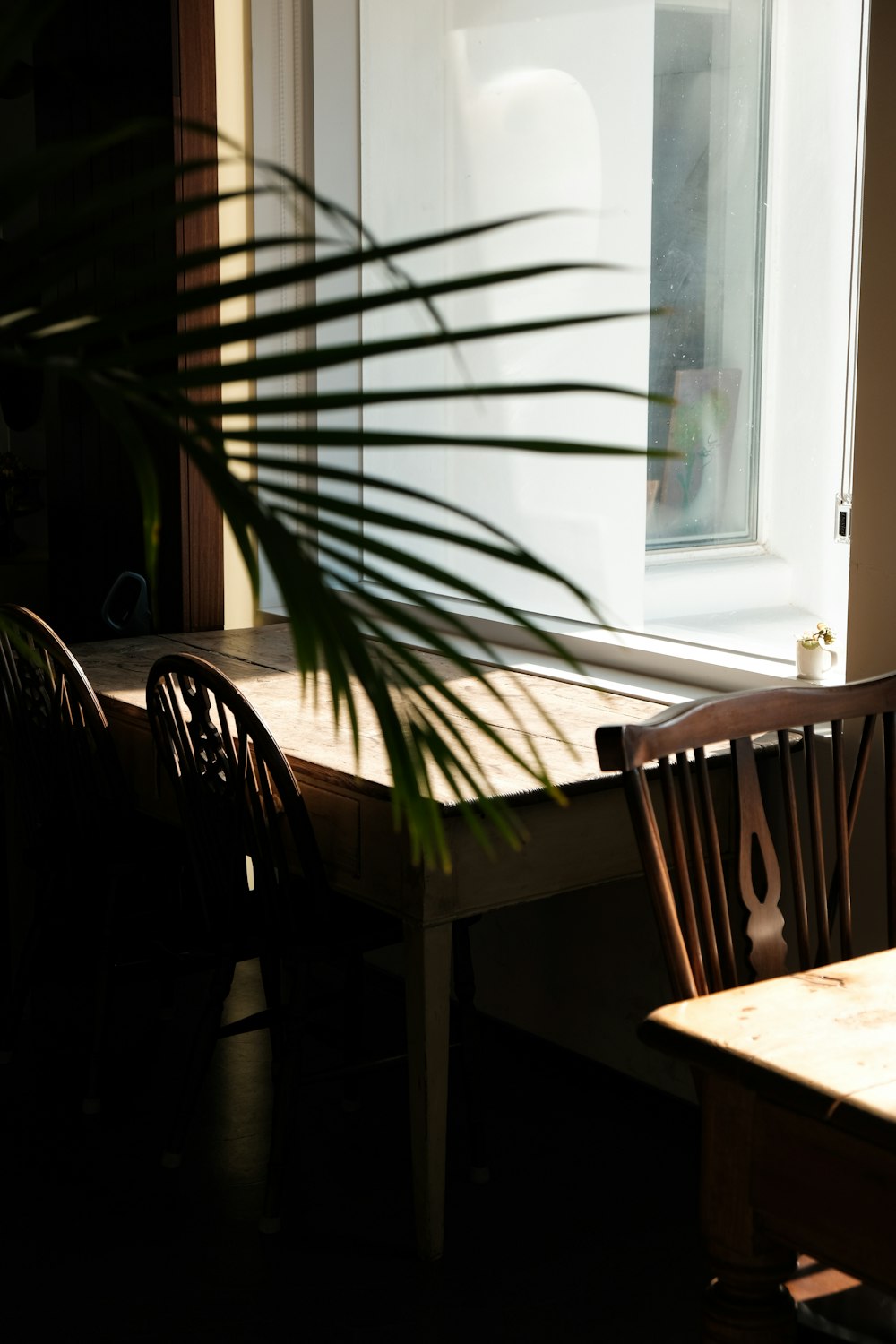 a dining room table and chairs in front of a window