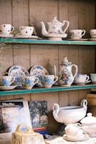 A collection of Chinese tea sets with intricate designs, displayed elegantly on a wooden shelf.