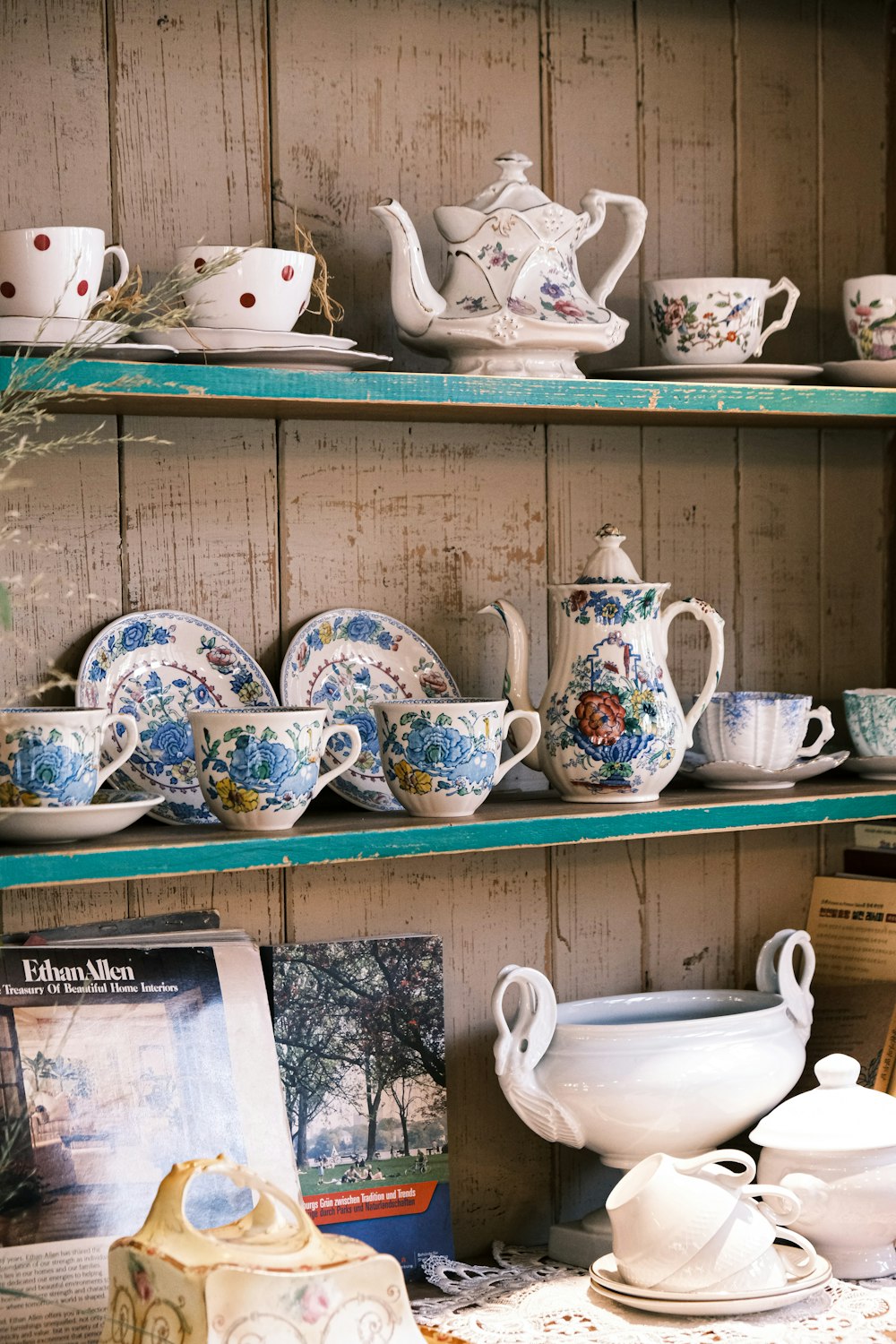 a shelf filled with lots of china on top of a table