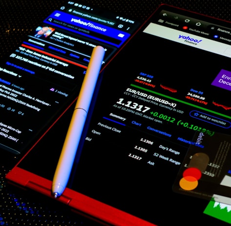 a cell phone with a pen on top of it