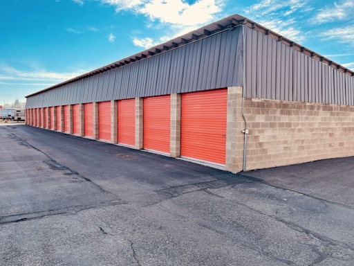 a storage building with red doors and a sky background