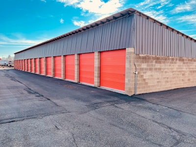 a storage building with red doors and a sky background
