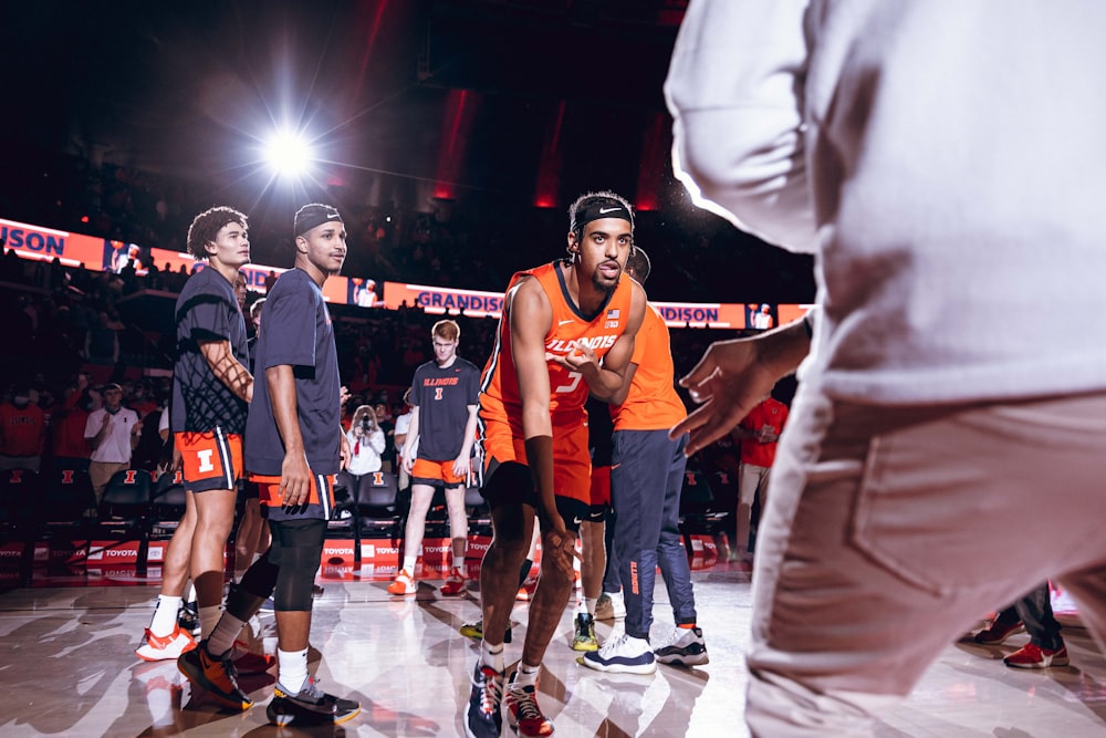 a group of young men standing on top of a basketball court