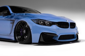 a blue sports car parked in a studio