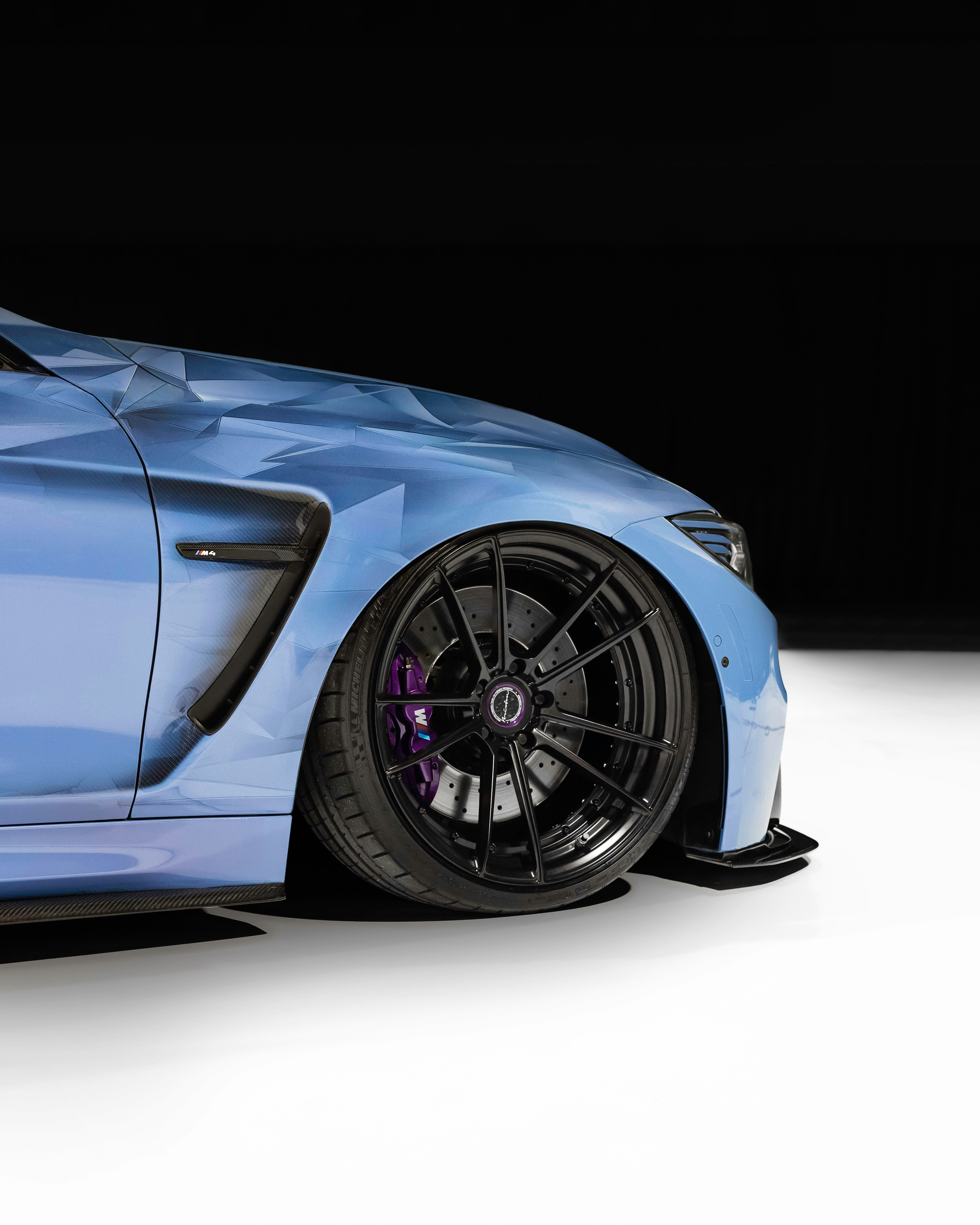 a blue sports car parked in a dark room