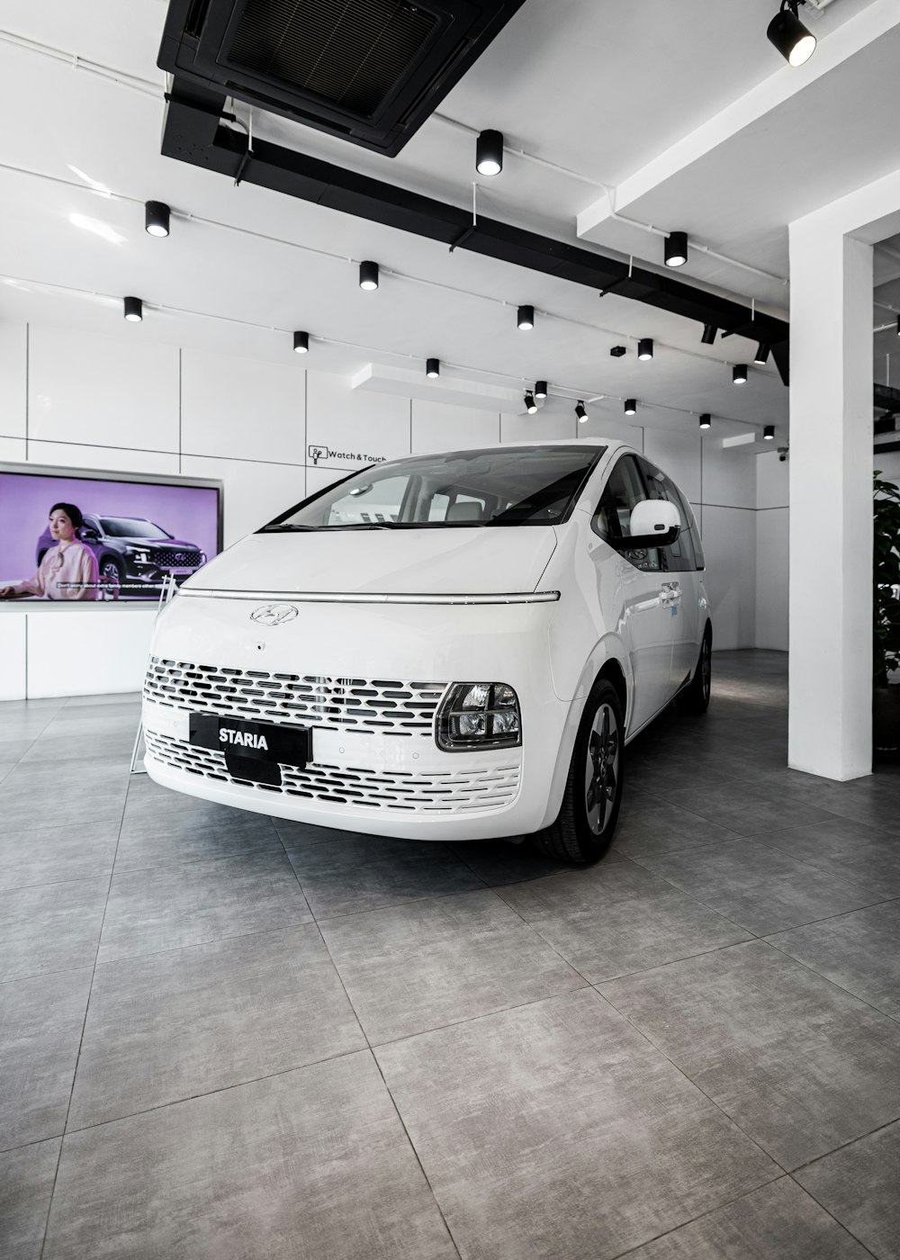 a white car is parked in a showroom