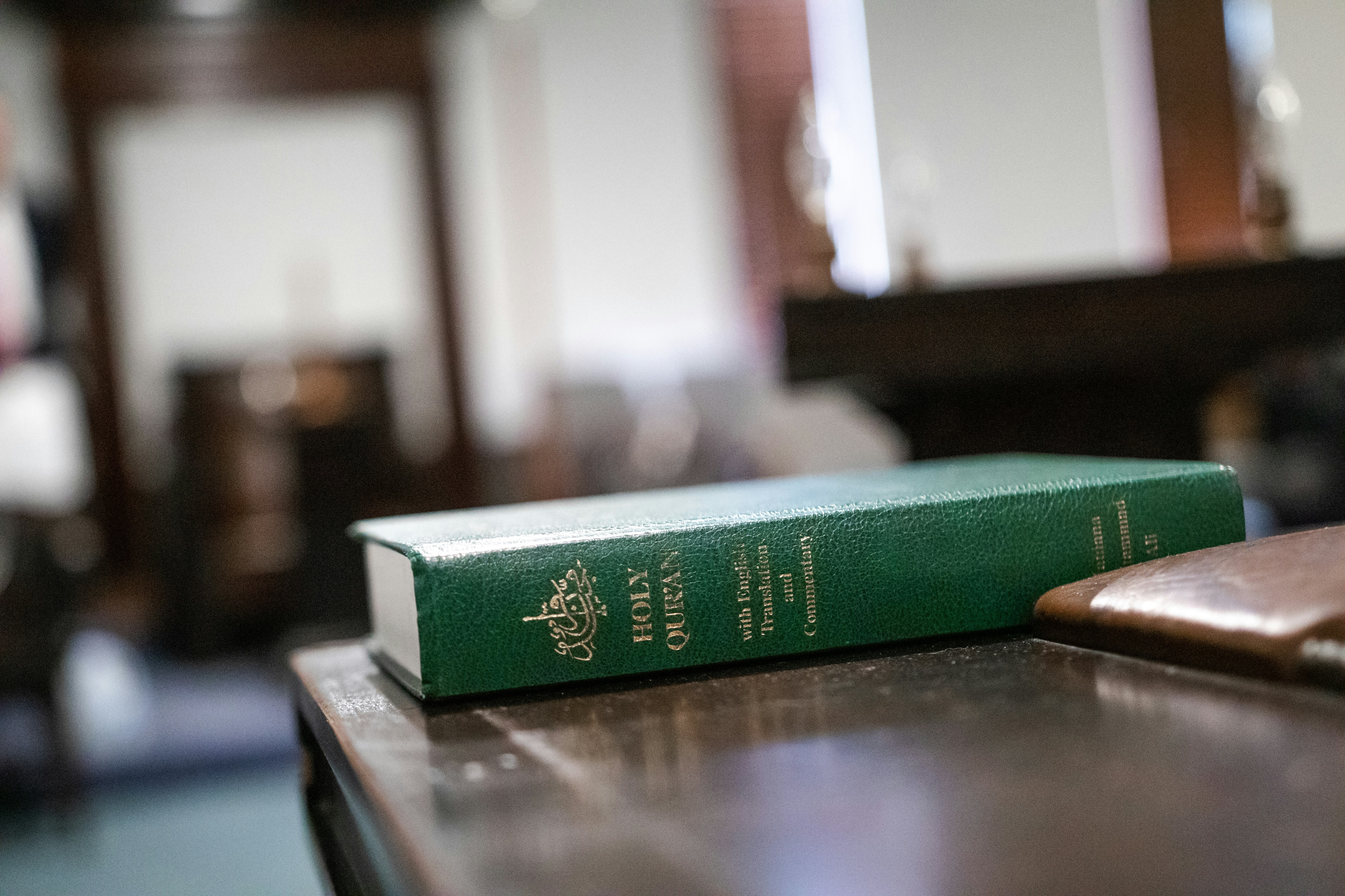 ein grünes Buch, das auf einem Holztisch sitzt