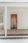 Rustic wooden barn-style door set against a cozy home exterior.