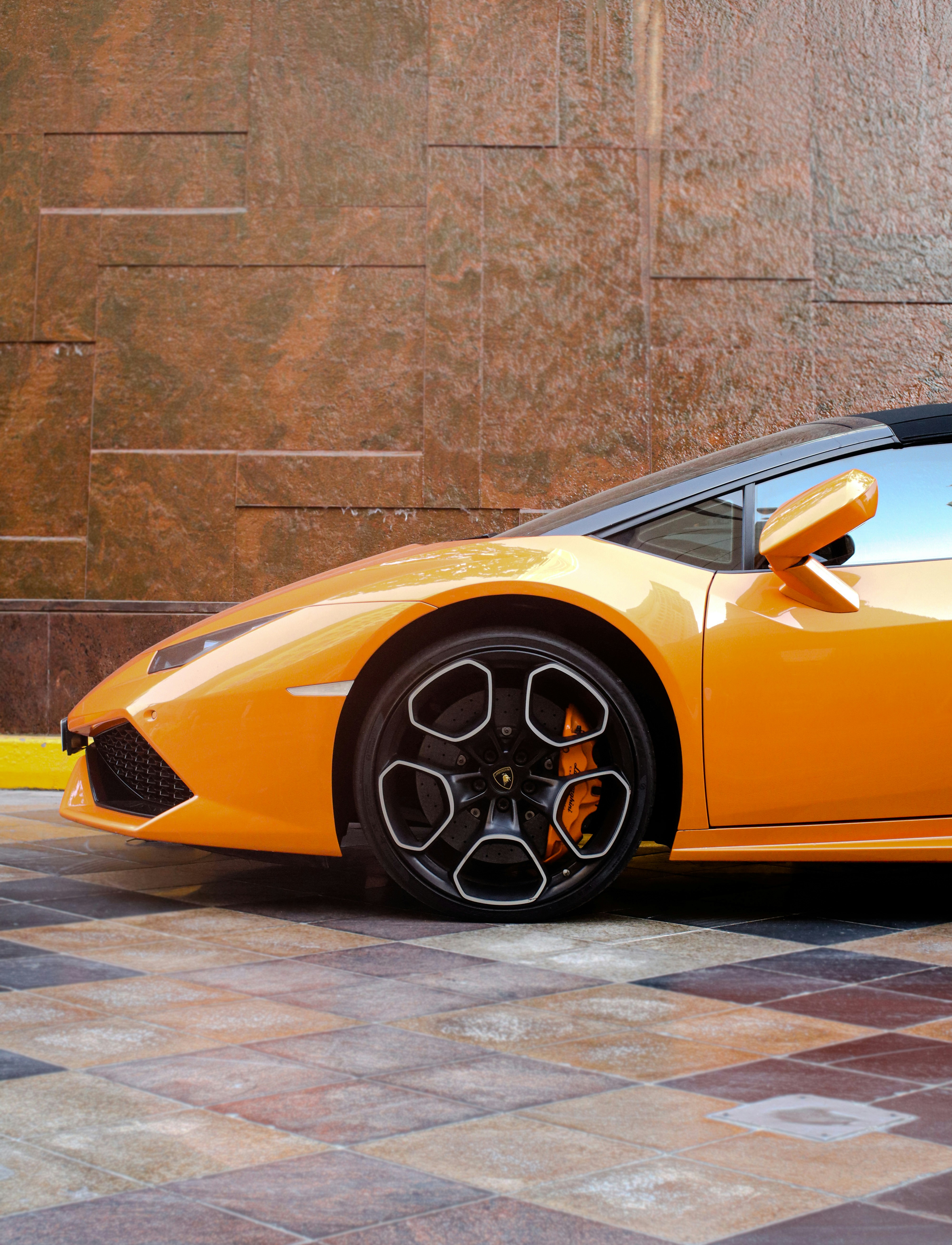 a yellow sports car parked in front of a building