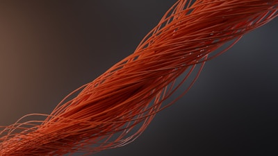 a close up of an orange wire on a black background