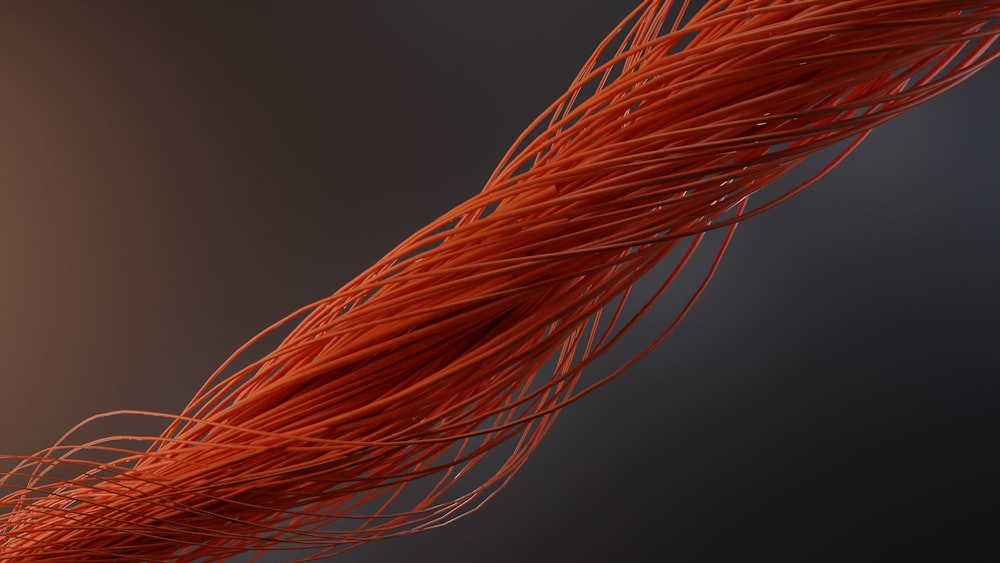 a close up of an orange wire on a black background