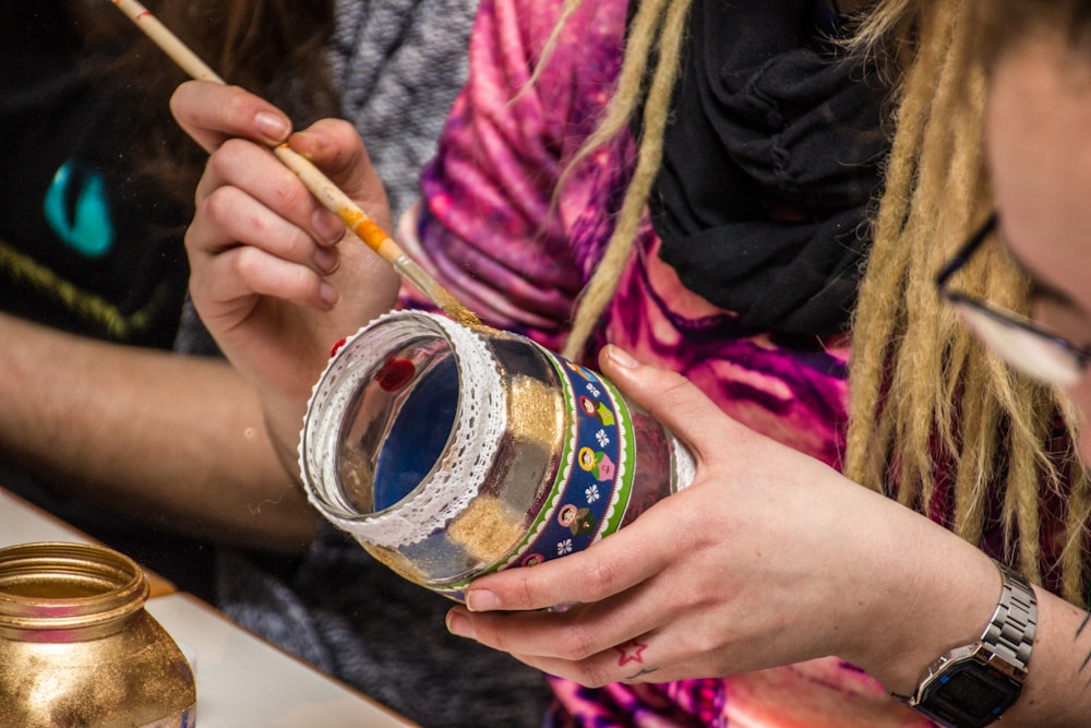 a group of people sitting around a table with a jar of paint