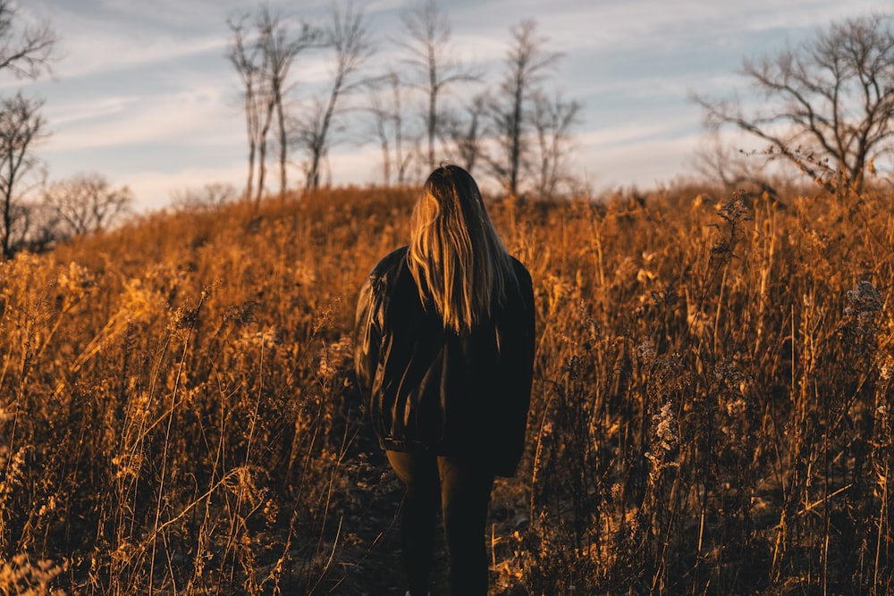 a person standing in a field of tall grass