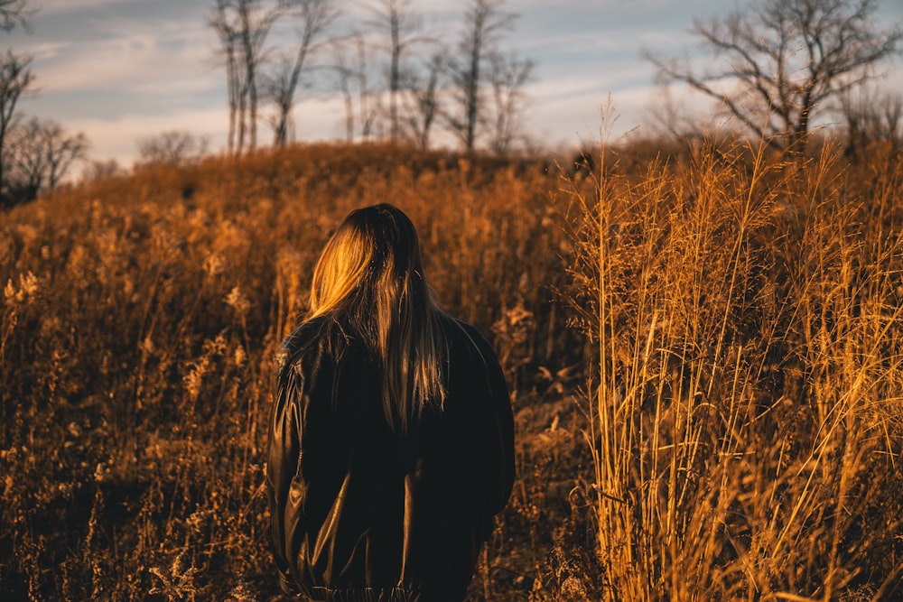 une personne debout dans un champ d’herbes hautes