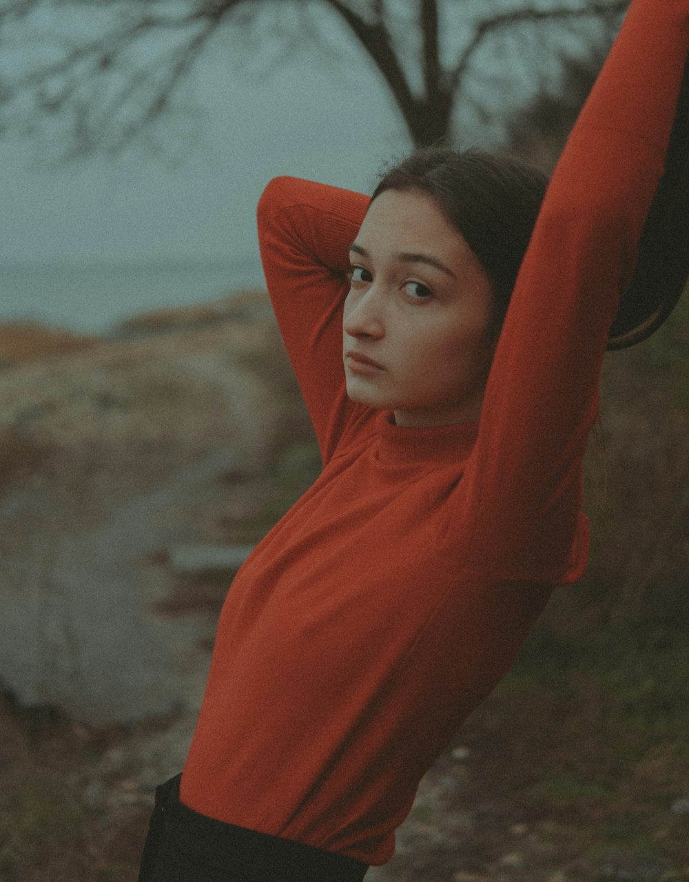 a woman in a red shirt is holding her arms up