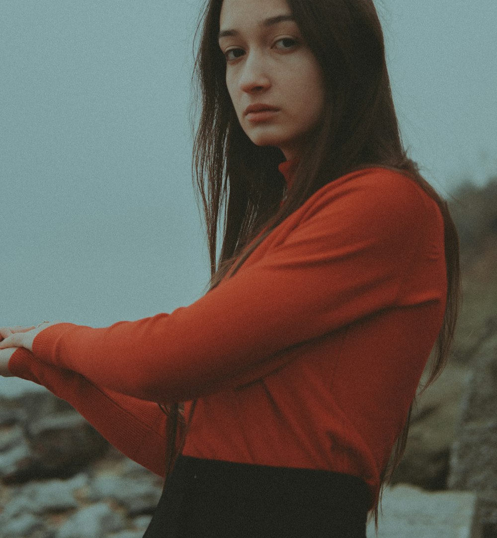 a woman in a red shirt and black skirt