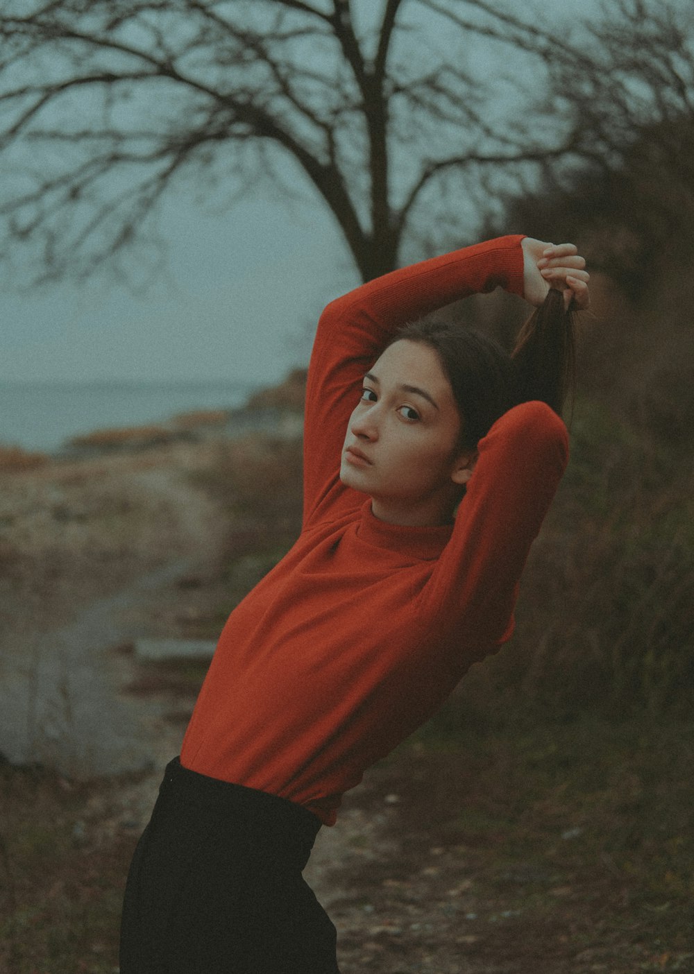 Una mujer con una camisa roja estira los brazos