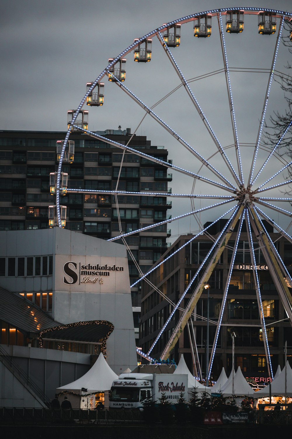 a large ferris wheel sitting in front of a tall building