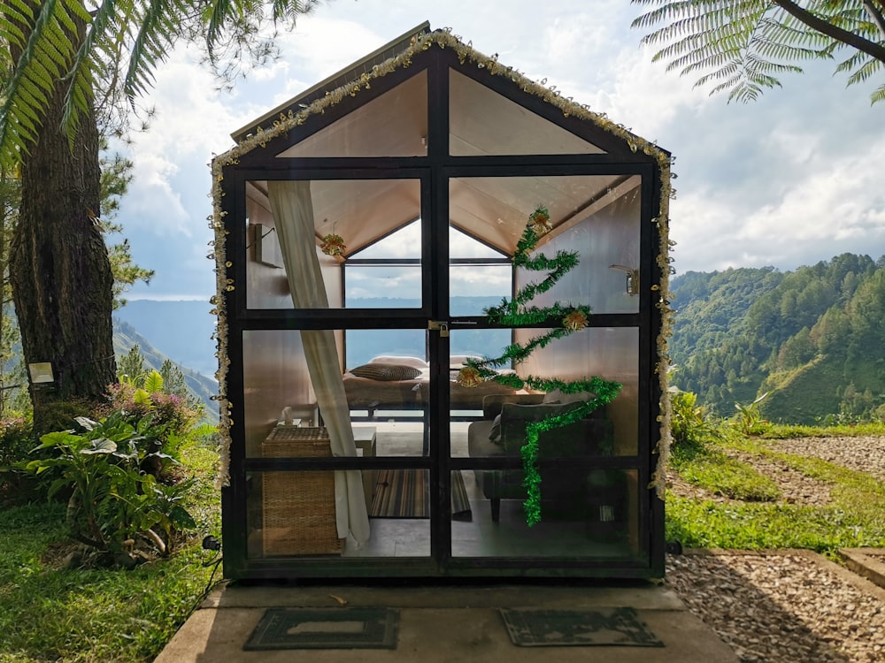 a small house made out of glass with a view of the ocean