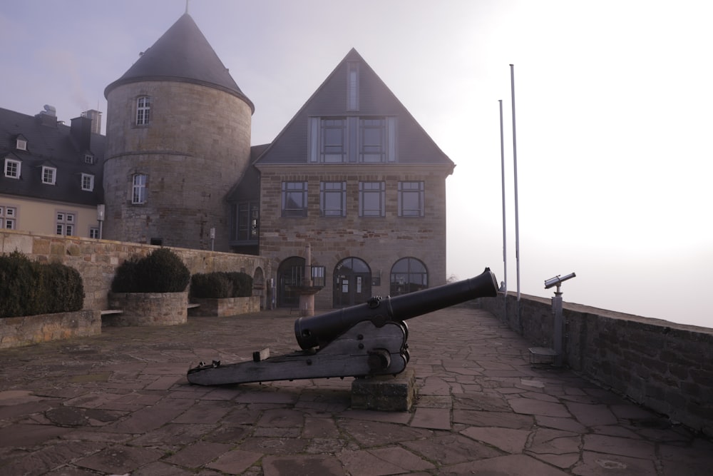 a cannon is sitting on the ground in front of a castle