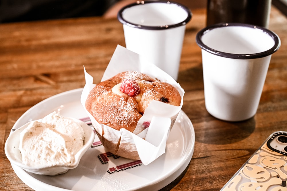 a white plate topped with a muffin covered in powdered sugar