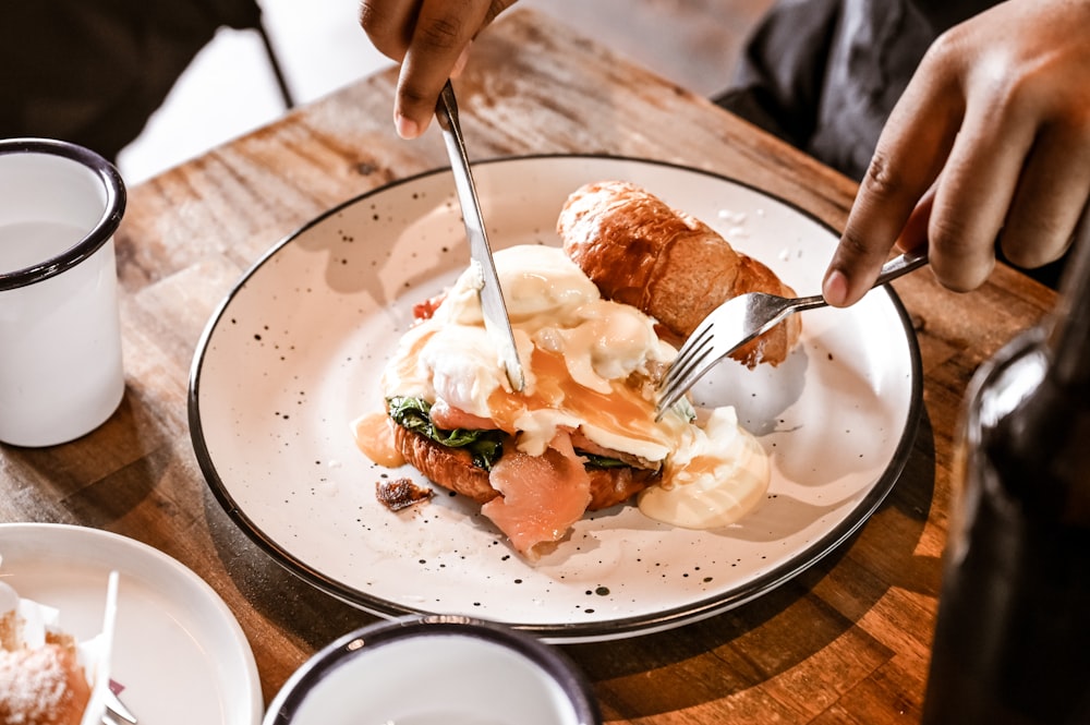 a person is cutting into a plate of food