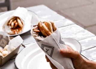 a person holding a napkin over a plate of food