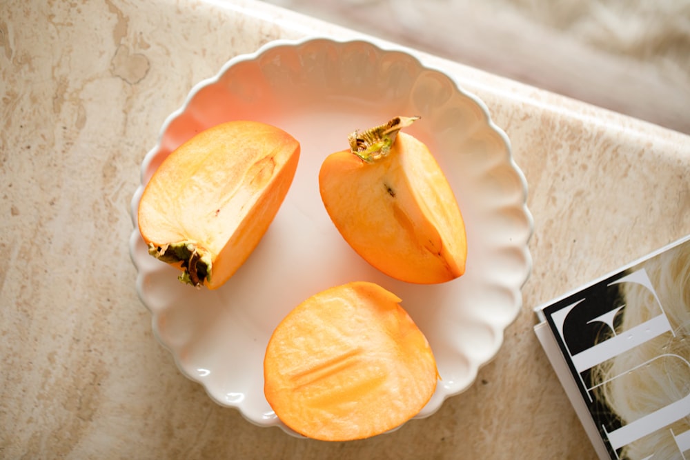 a white plate topped with sliced peaches next to a book