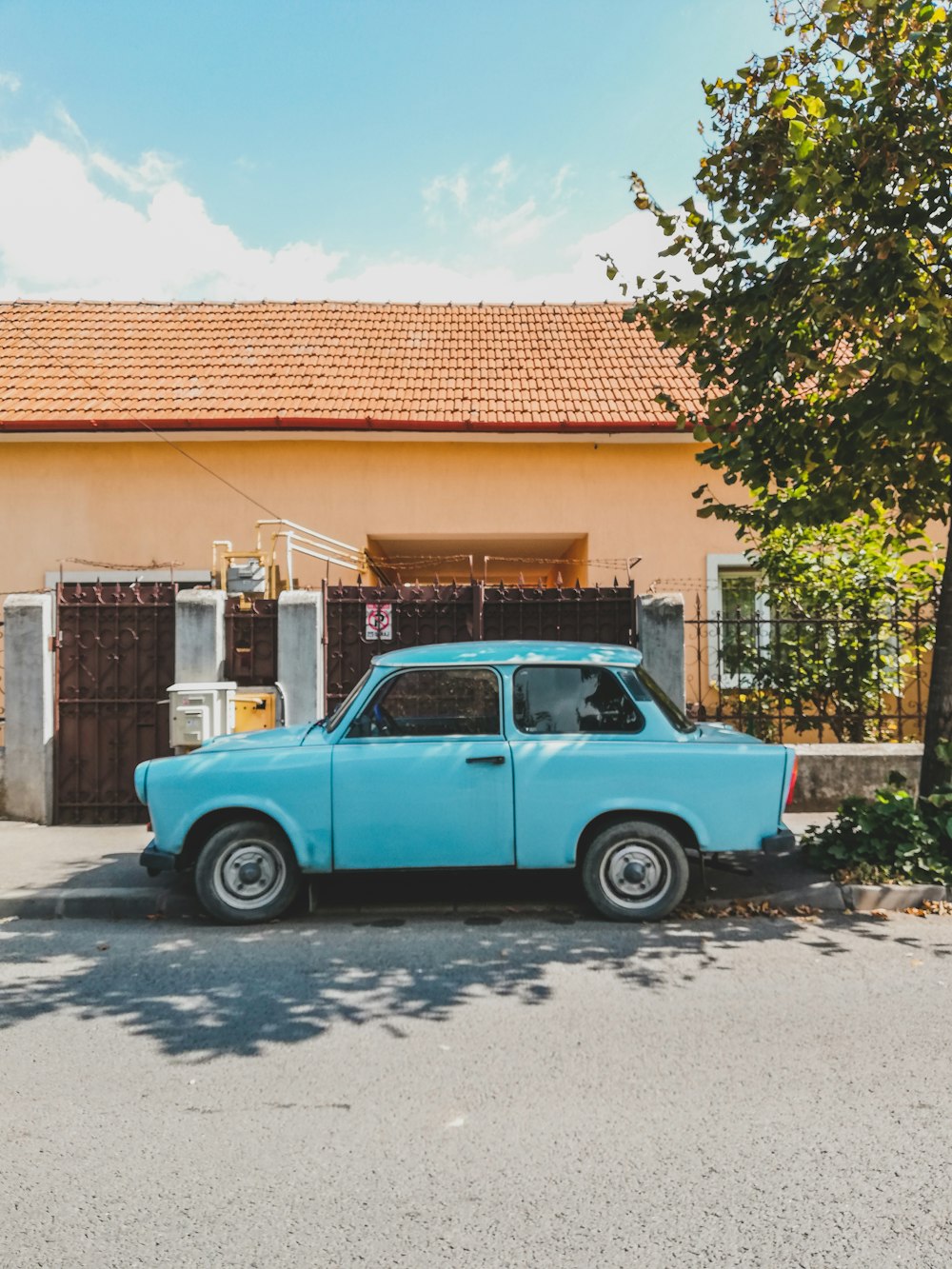 a blue car parked in front of a house