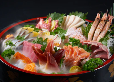 A plate of fresh sashimi, finely sliced raw fish arranged on a serving dish