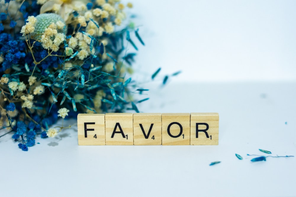 a wooden block that says flavor next to a bouquet of flowers