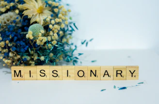a wooden block that says,'missionary'next to a bouquet of flowers