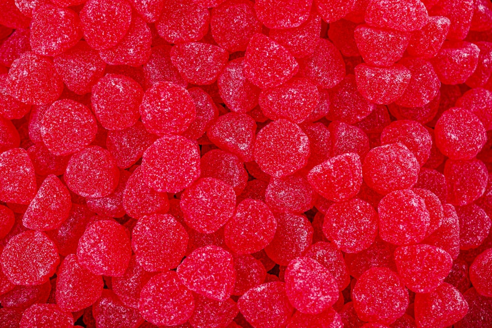 a close up of a pile of red candy hearts