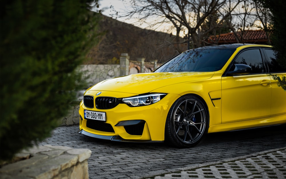 a yellow car parked on a brick road