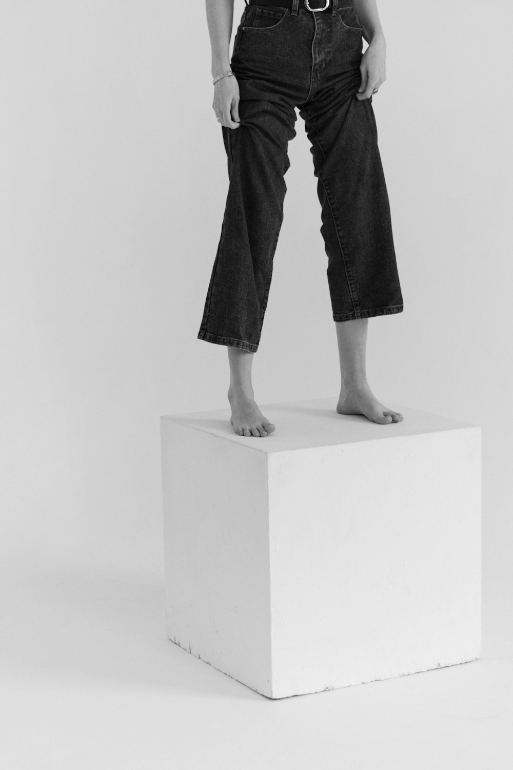 a woman standing on top of a white block