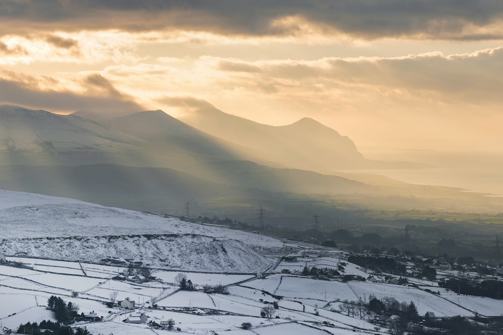 a snowy landscape with mountains in the background