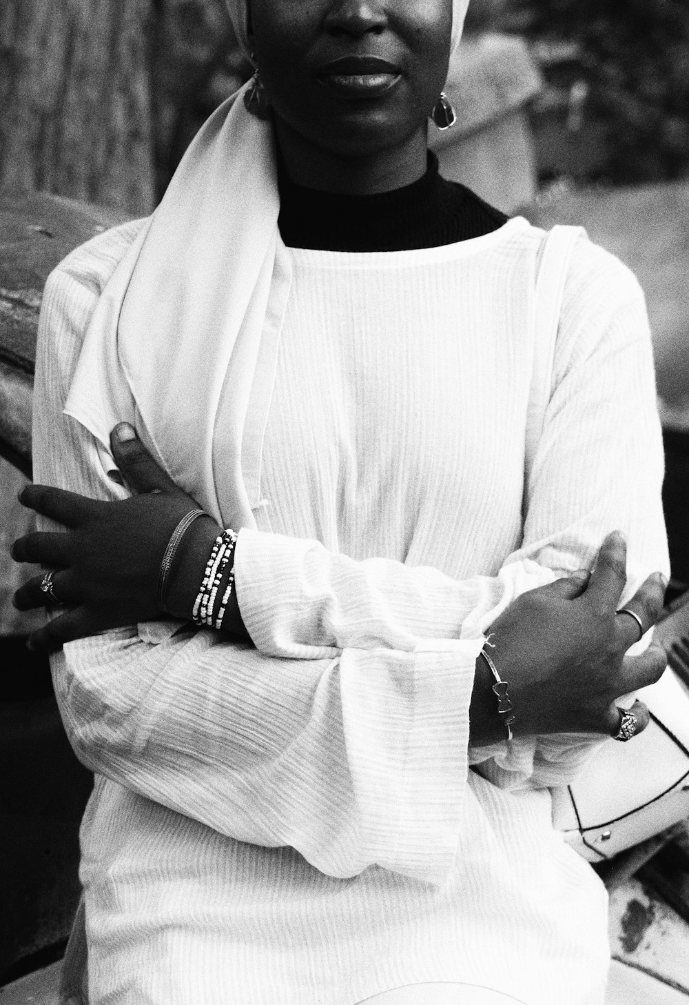 a woman wearing a head scarf sitting on a bench