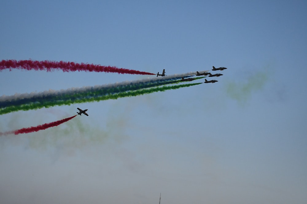 a group of jets flying through a blue sky