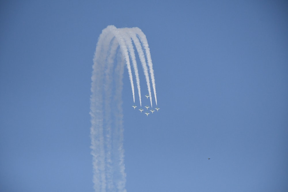 a group of jets flying through a blue sky